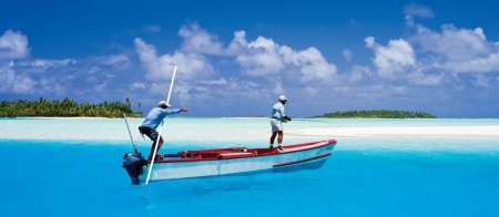 a blue and white boat sitting next to a body of water