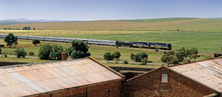 a train traveling down train tracks near a field