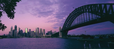 a bridge over a body of water with a city in the background