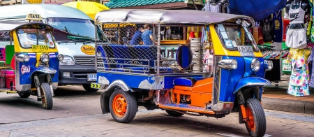 a yellow and blue truck driving down a street